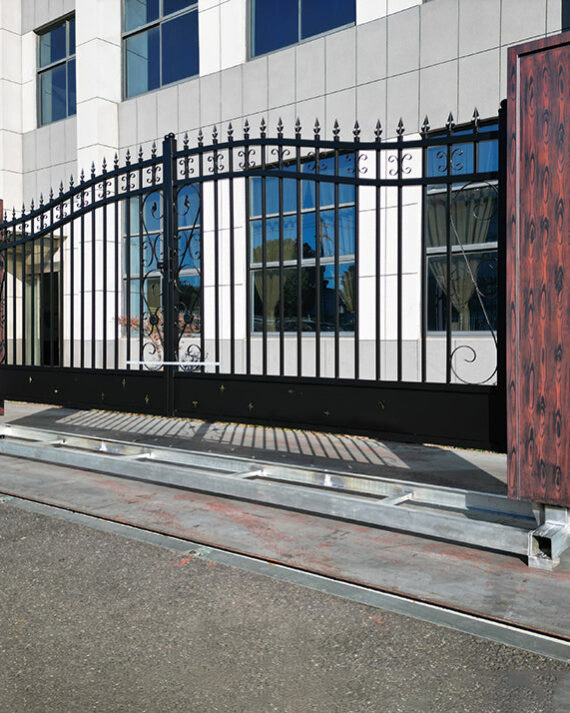 Metallic driveway gate with wooden panels in front of a building