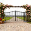 Decorative black metal gate with floral archway in a garden setting